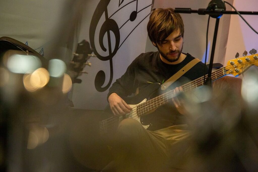 Yo en mi estudio con mi bajo eléctrico de 5 cuerdas de Fender